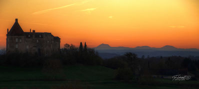 Vue sur le chateau de Louchy et le Puy-de-Dome au soleil couchant.